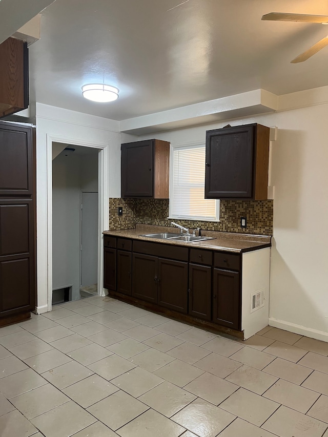 kitchen featuring sink, dark brown cabinets, light tile patterned floors, ceiling fan, and backsplash