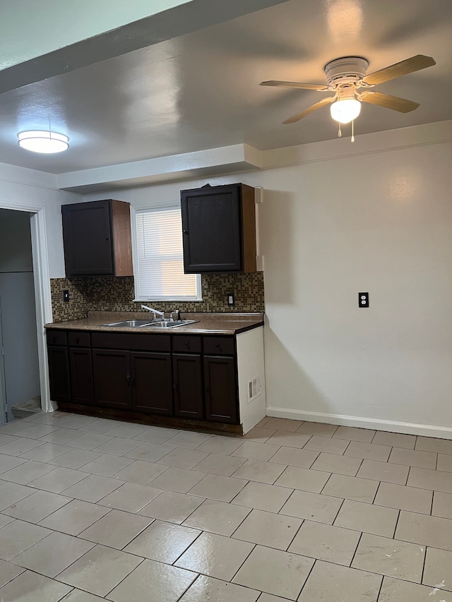 kitchen featuring dark brown cabinetry, sink, backsplash, and ceiling fan