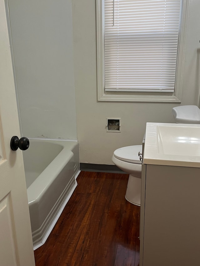 bathroom with vanity, hardwood / wood-style flooring, a tub, and toilet