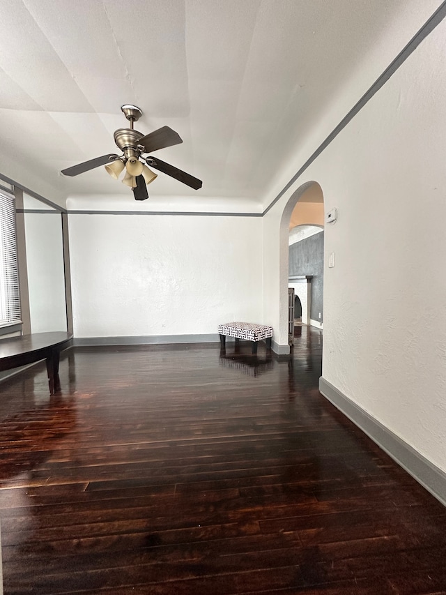 unfurnished room featuring dark wood-type flooring and ceiling fan