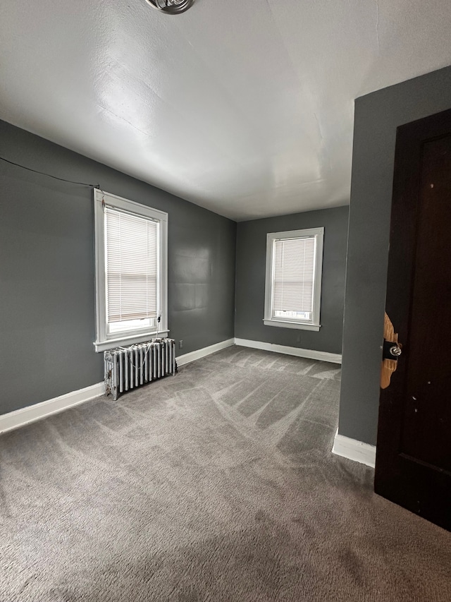 carpeted empty room with radiator