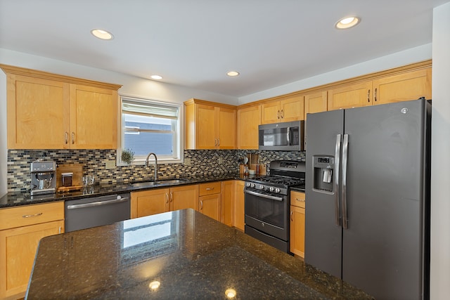 kitchen with light brown cabinets, stainless steel appliances, dark stone counters, tasteful backsplash, and sink