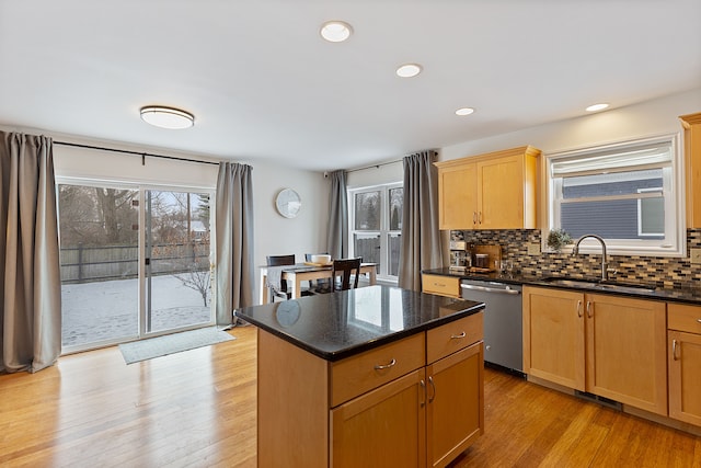 kitchen featuring a center island, sink, backsplash, light wood-type flooring, and stainless steel dishwasher