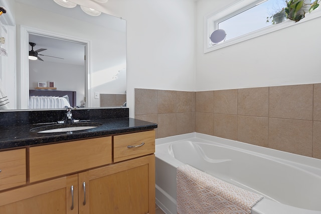 bathroom with ceiling fan, a bathtub, and vanity