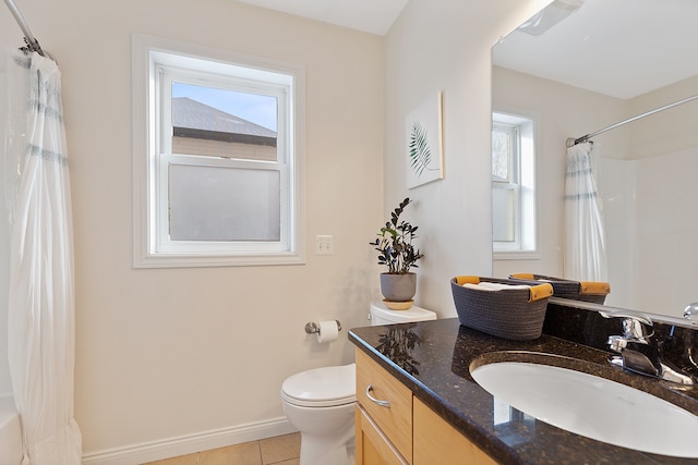 bathroom featuring a wealth of natural light, toilet, vanity, and tile patterned flooring