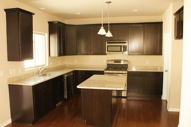 kitchen featuring a kitchen island, decorative light fixtures, dark hardwood / wood-style flooring, stainless steel appliances, and sink