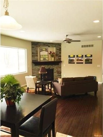 dining space featuring hardwood / wood-style flooring, ceiling fan, and a fireplace