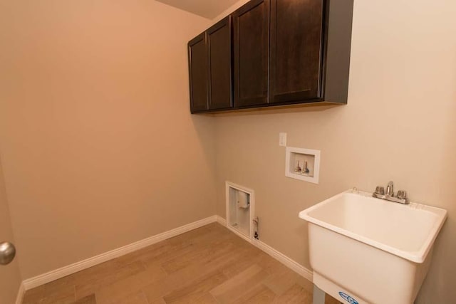 laundry room featuring light hardwood / wood-style floors, gas dryer hookup, sink, hookup for a washing machine, and cabinets