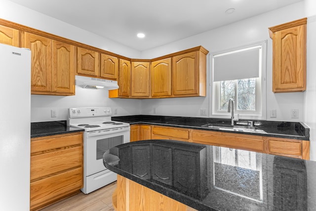 kitchen featuring light hardwood / wood-style floors, sink, white appliances, and dark stone countertops