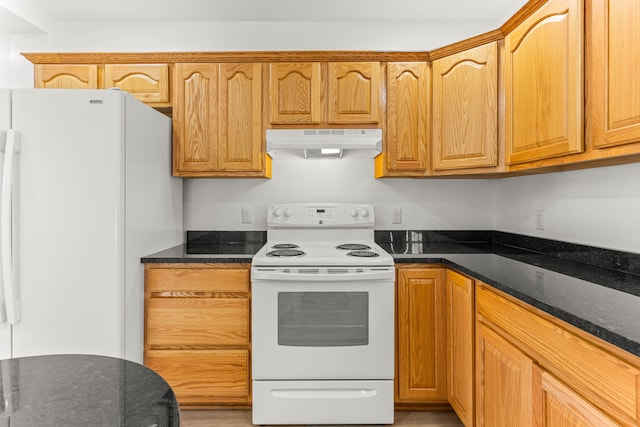 kitchen featuring white appliances and dark stone counters