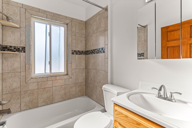 full bathroom featuring toilet, tiled shower / bath, and vanity