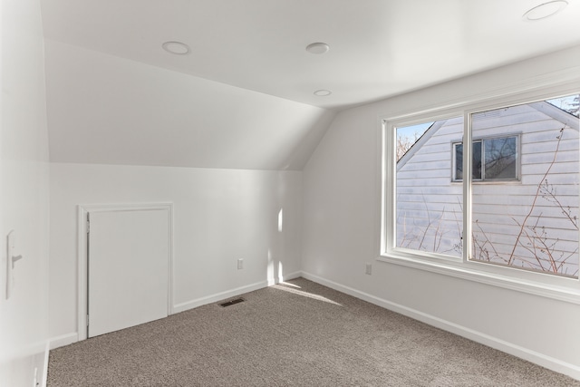 bonus room with carpet floors and vaulted ceiling