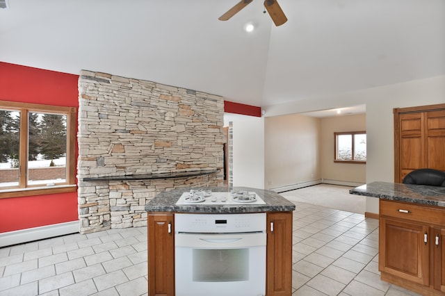 kitchen featuring a kitchen island, white appliances, a baseboard heating unit, and light tile patterned flooring