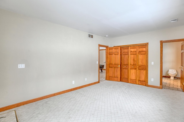 unfurnished bedroom with a closet, carpet, and connected bathroom