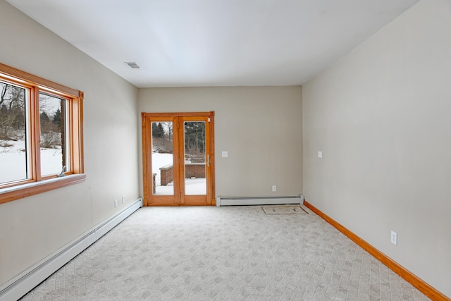 empty room featuring baseboard heating, light carpet, and french doors