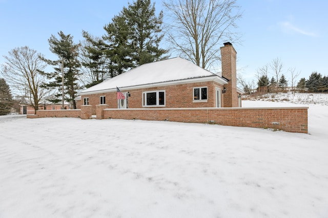 view of snow covered back of property