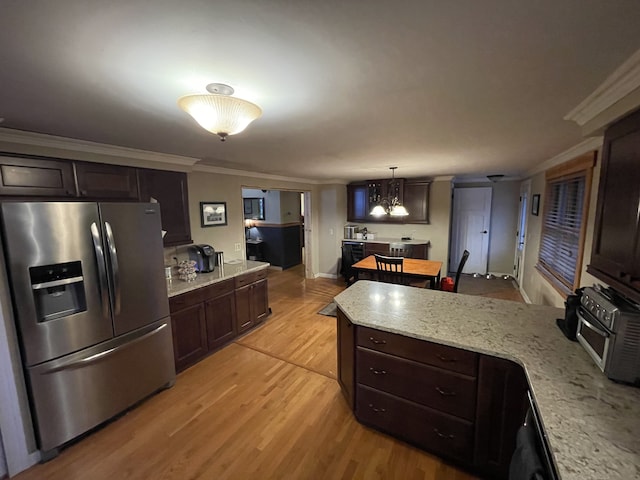 kitchen featuring light stone countertops, stainless steel fridge, hanging light fixtures, and ornamental molding