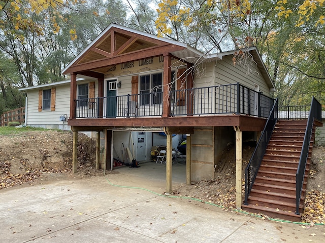 view of front facade featuring concrete driveway and stairway