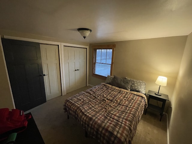 bedroom with light carpet and two closets