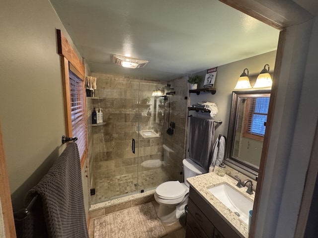 bathroom featuring toilet, a stall shower, and vanity