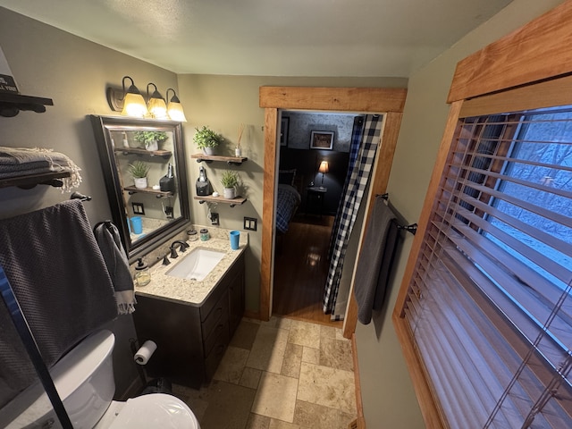 bathroom with stone tile floors and vanity