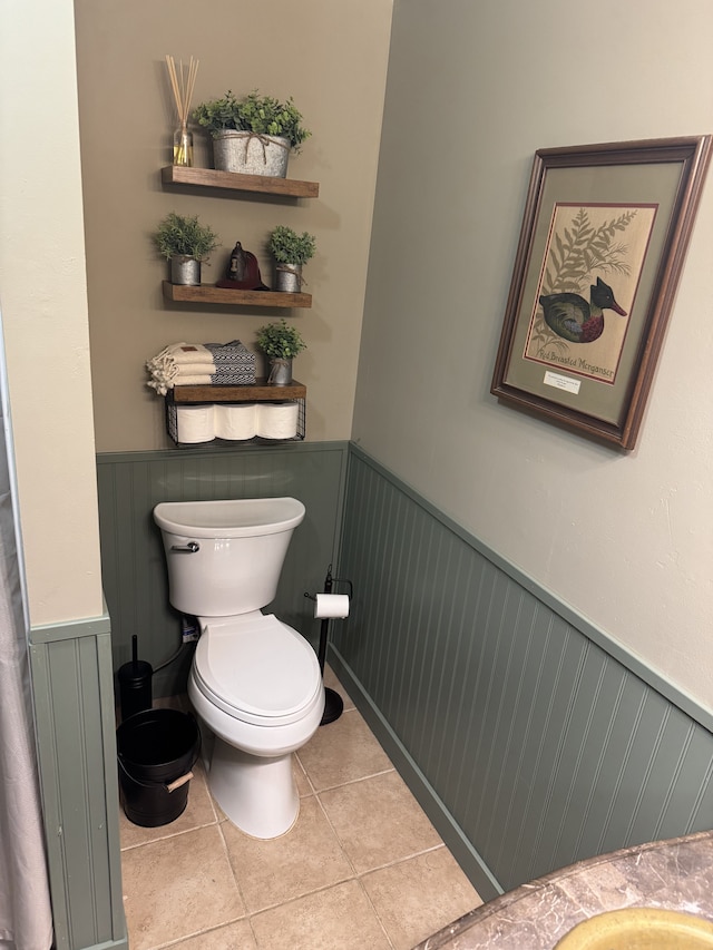 bathroom featuring a wainscoted wall, toilet, and tile patterned floors