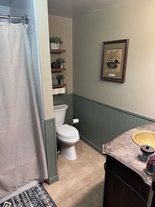 full bathroom featuring toilet, wainscoting, tile patterned flooring, and vanity