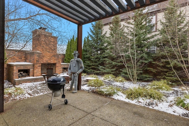 snow covered patio featuring an outdoor stone fireplace