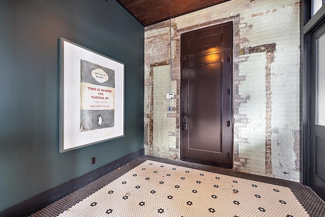 entryway featuring brick wall and wood ceiling