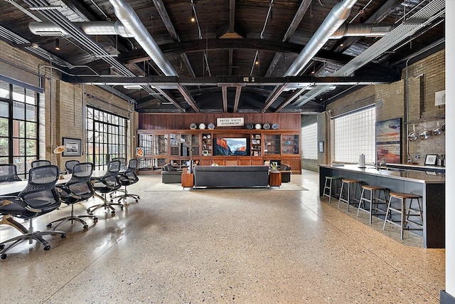 misc room with wooden walls, high vaulted ceiling, and a wealth of natural light