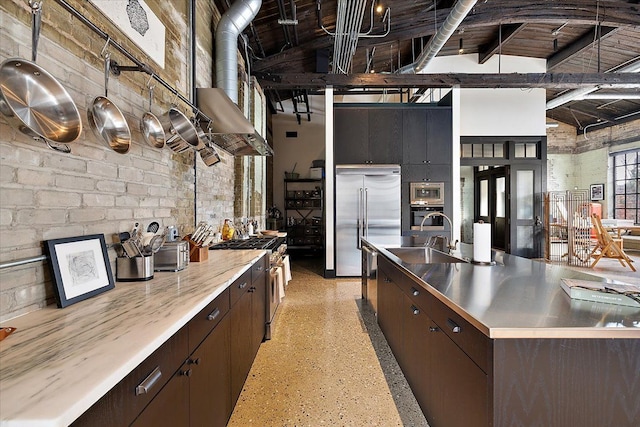 kitchen featuring built in appliances, sink, dark brown cabinetry, and beamed ceiling