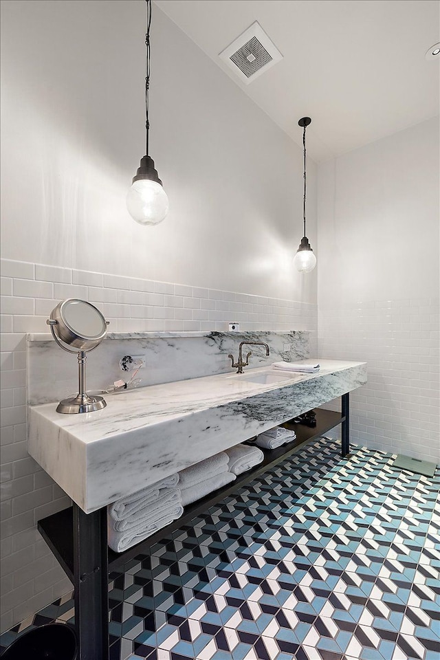 bathroom with sink and tile walls