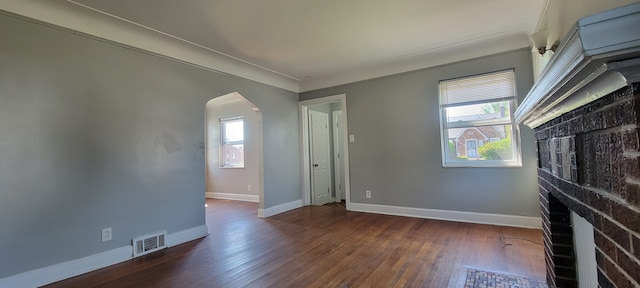 unfurnished living room featuring dark wood-type flooring and a wealth of natural light