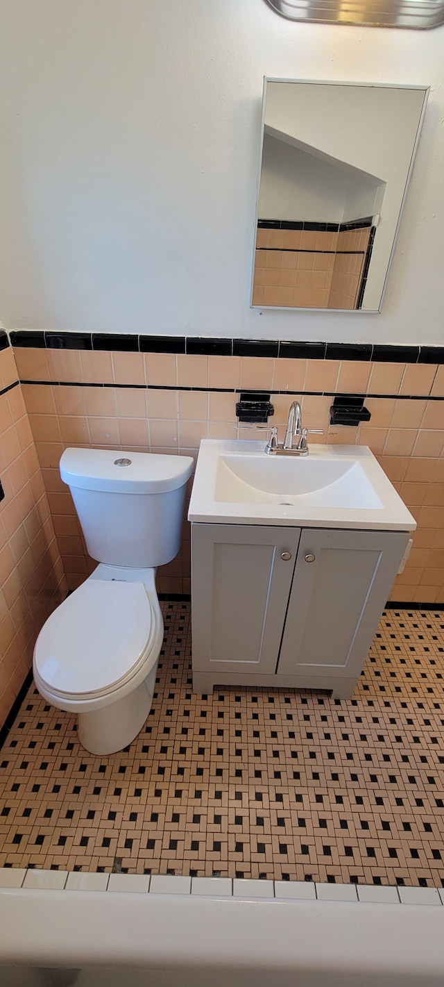 bathroom featuring vanity, tile walls, tile patterned floors, and toilet