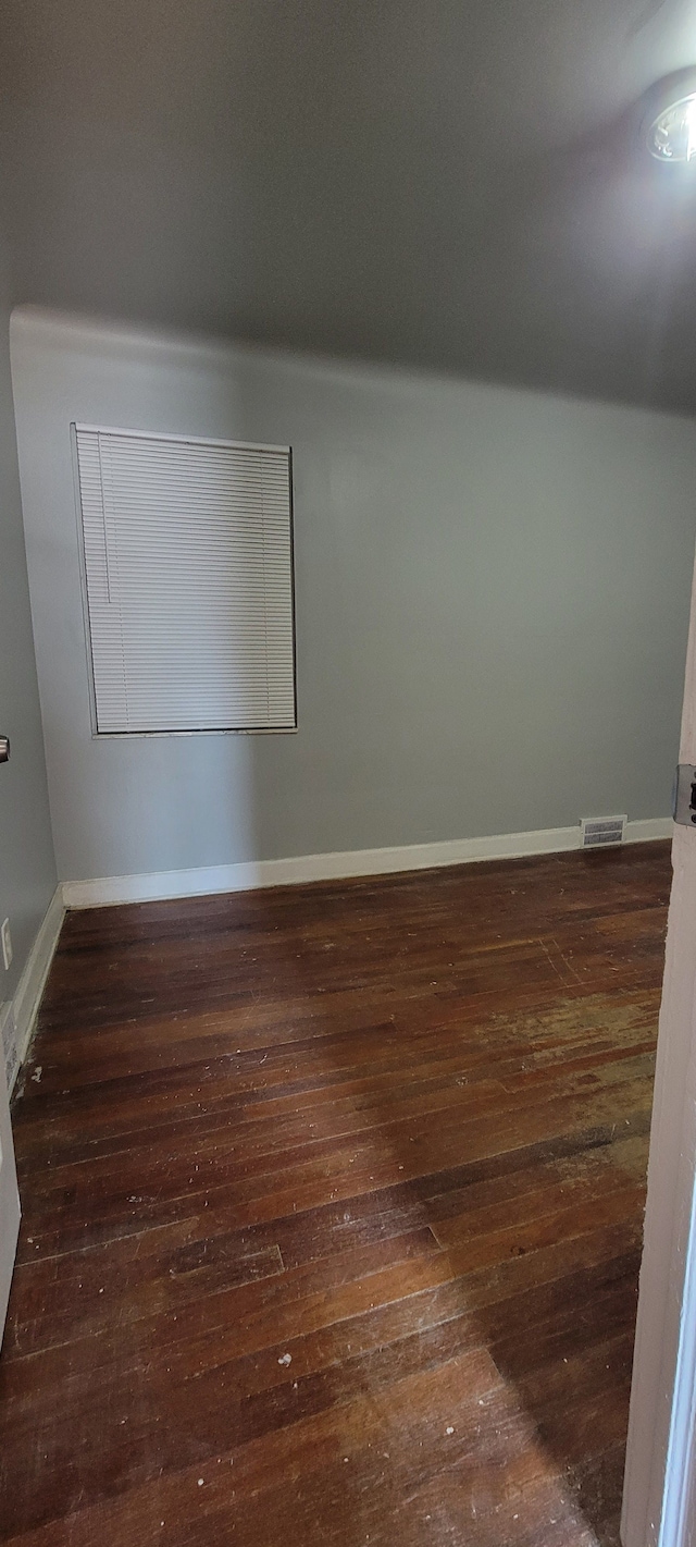 empty room with dark hardwood / wood-style flooring