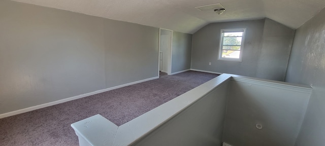 additional living space featuring vaulted ceiling and carpet flooring