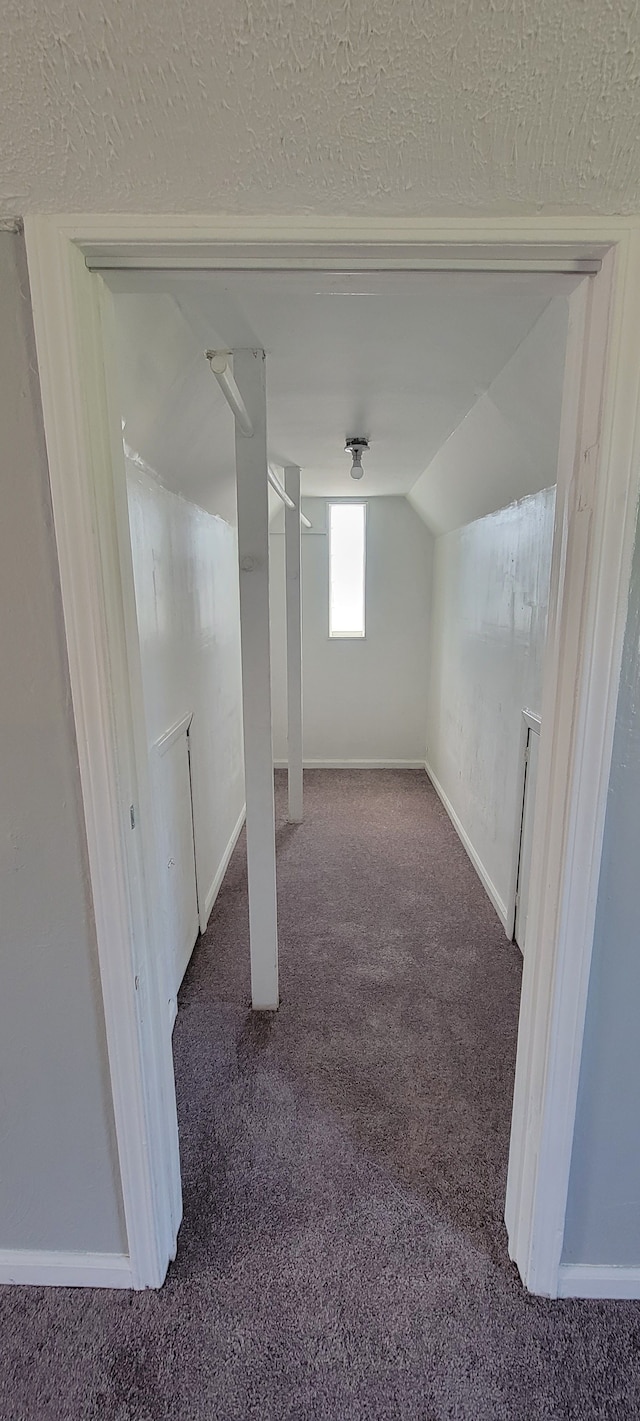 bonus room featuring dark carpet, vaulted ceiling, and a textured ceiling