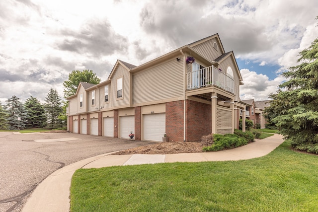 view of property exterior featuring a balcony, a lawn, and a garage