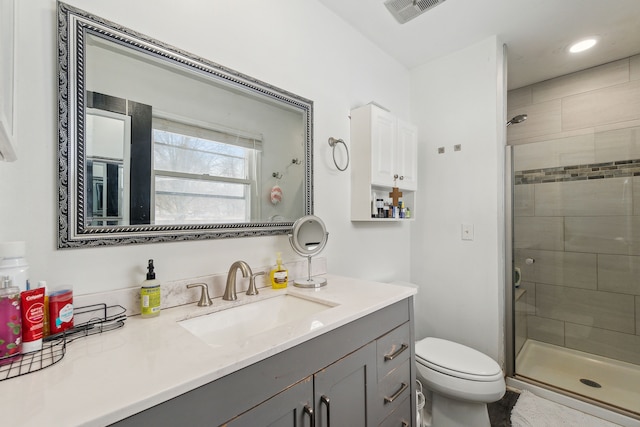 bathroom with vanity, toilet, and a shower with shower door