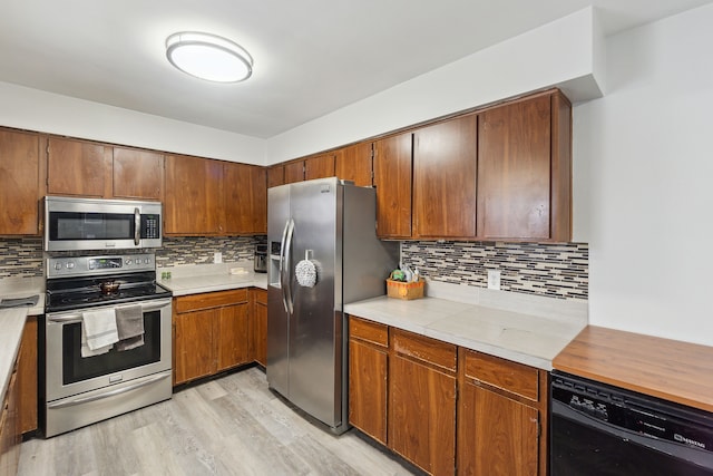 kitchen featuring tasteful backsplash, appliances with stainless steel finishes, and light hardwood / wood-style flooring