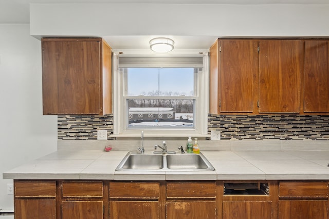 kitchen featuring sink, tile counters, and decorative backsplash