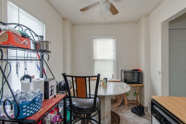 tiled dining space featuring crown molding, ceiling fan, and a wealth of natural light