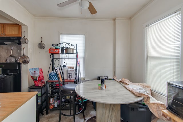 tiled dining room featuring crown molding and ceiling fan