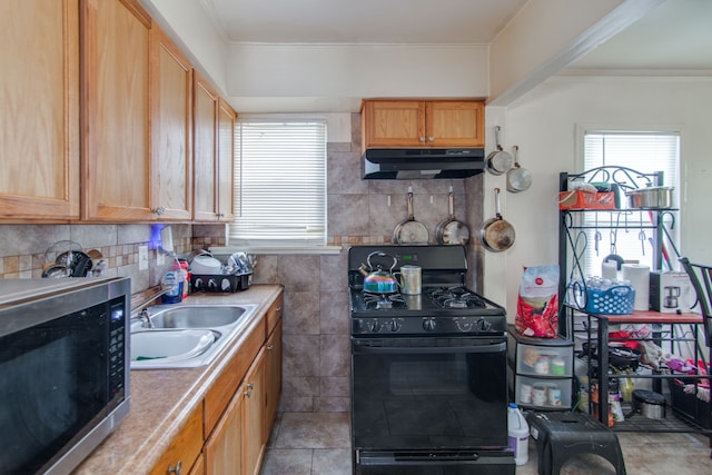 kitchen featuring black range with gas cooktop, tasteful backsplash, light tile patterned floors, sink, and ornamental molding