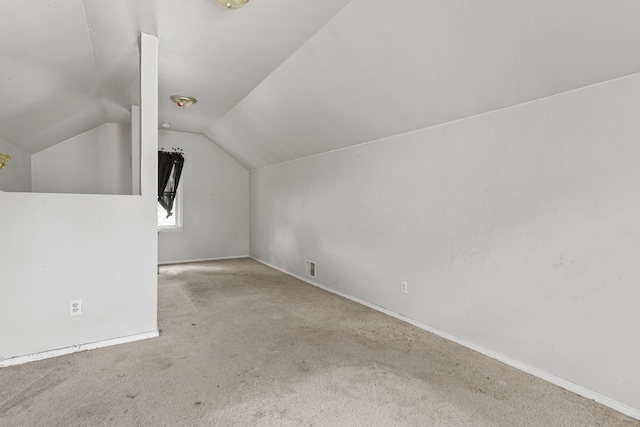 bonus room with light carpet and vaulted ceiling