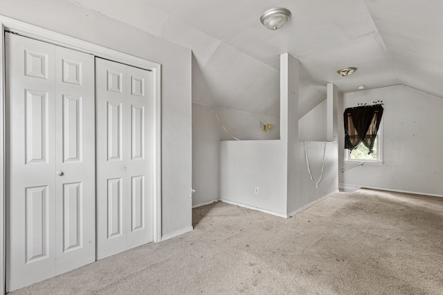 bonus room with vaulted ceiling and light colored carpet