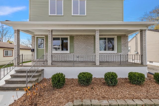 view of front facade with a porch and brick siding