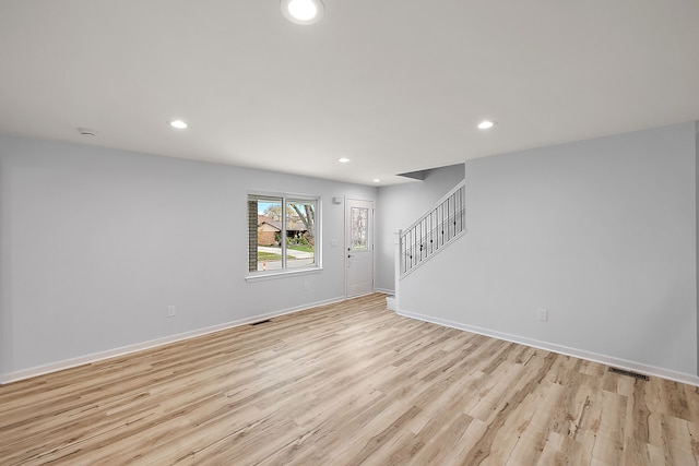 unfurnished room with stairs, light wood finished floors, baseboards, and recessed lighting