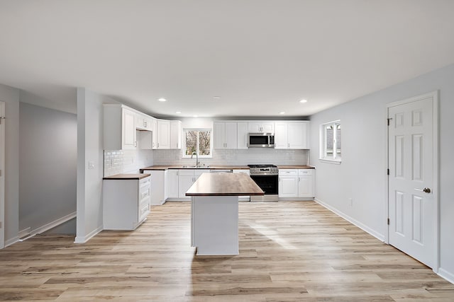 kitchen featuring appliances with stainless steel finishes, a wealth of natural light, and tasteful backsplash