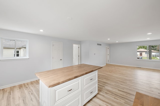 kitchen with butcher block countertops, recessed lighting, light wood-style flooring, and baseboards